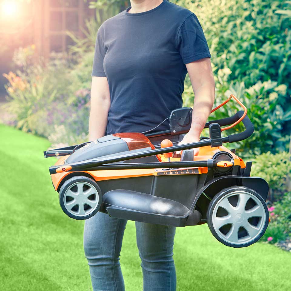 LawnMaster Cordless Lawn Mower 48V 41cm being carried across garden CLMF4841E