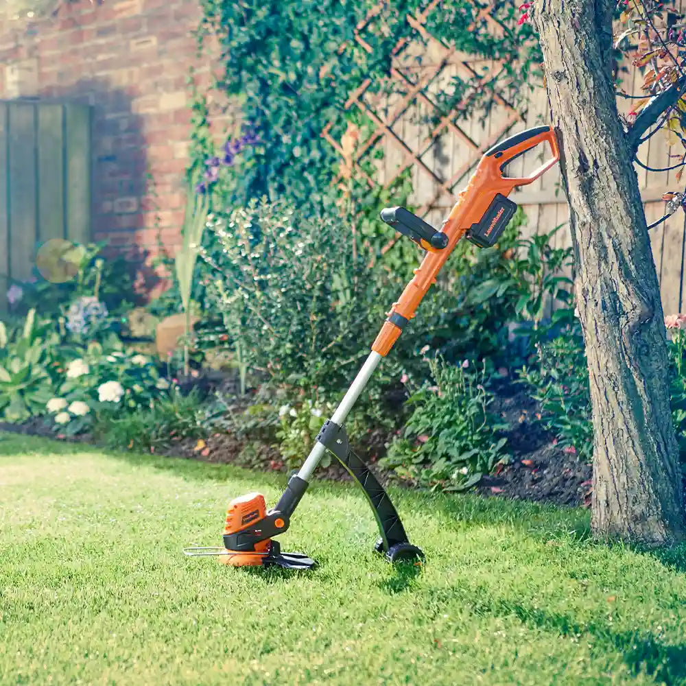 LawnMaster Cordless Grass Trimmer 24V CLGT2425S-03 mit angebrachtem Stützrad gegen einen Baum gelehnt