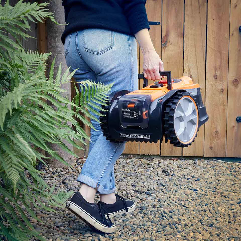 Rasenmähroboter Drop and Mow LawnMaster VBRM16 wird zur Lagerung in den Schuppen getragen