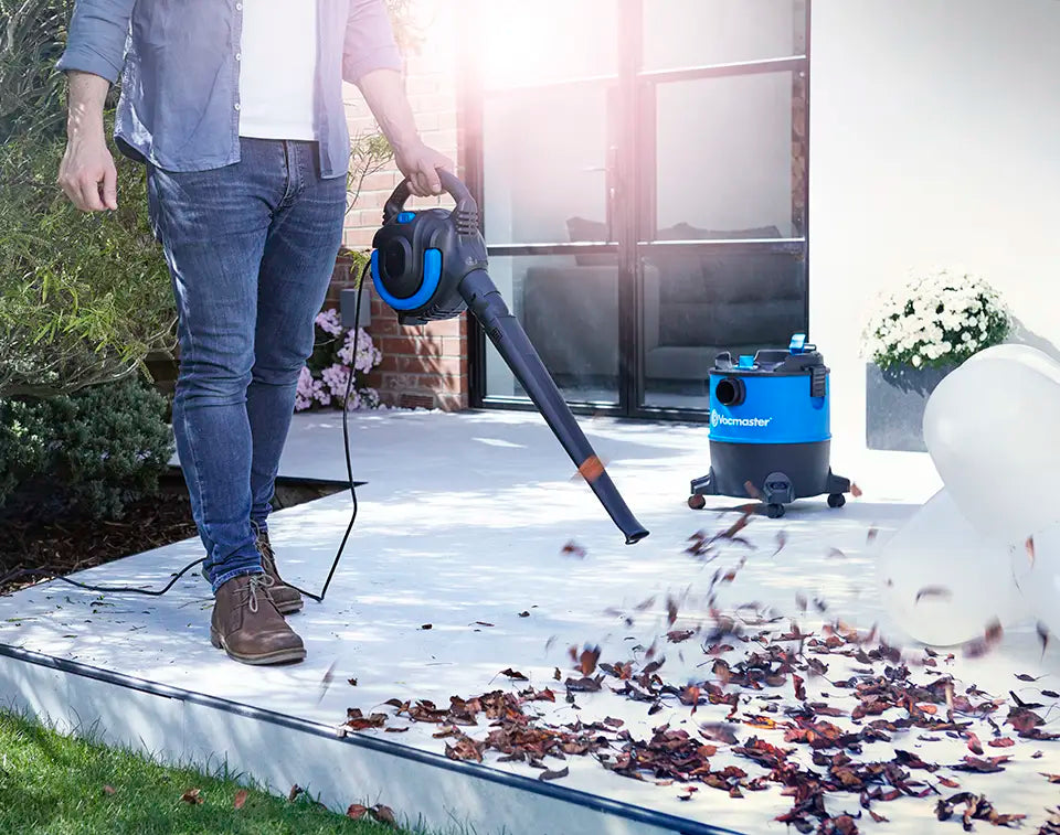 Vacmaster 2-in-1 wet dry vacuum with detachable blower blowing leaves off garden patio